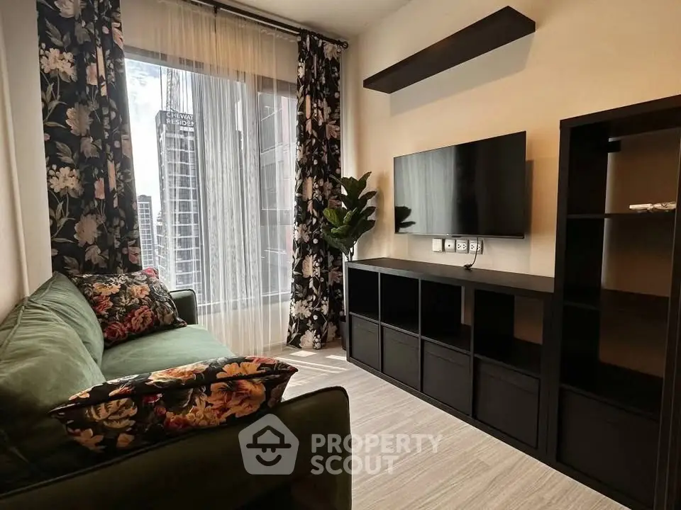 Stylish living room with floral decor and modern entertainment setup in urban apartment.