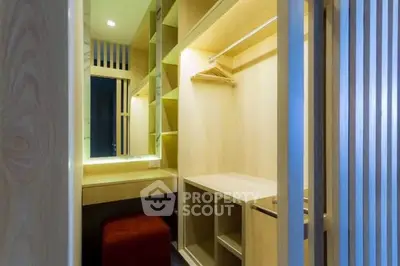 Spacious walk-in closet with modern wooden shelving and seating area.