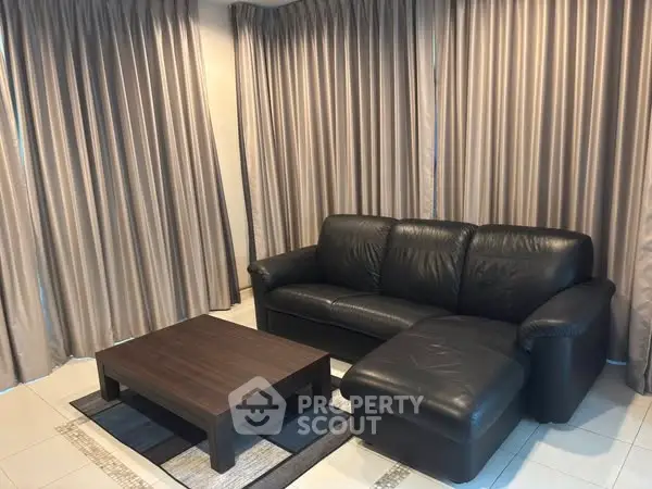 Elegant living room with black leather sofa and modern coffee table