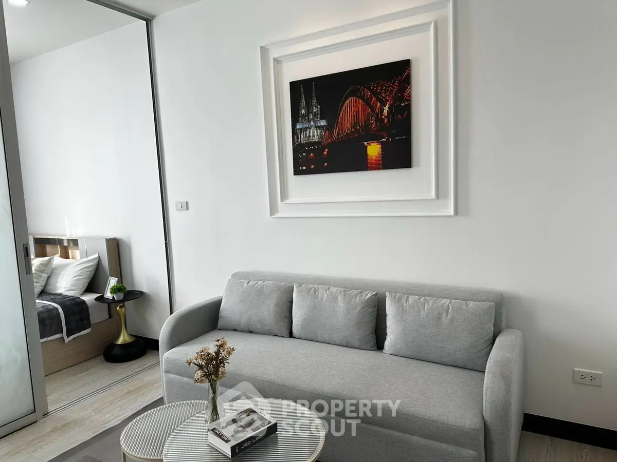 Modern living room with stylish decor and cozy sofa, adjacent to a chic bedroom, perfect for urban living.
