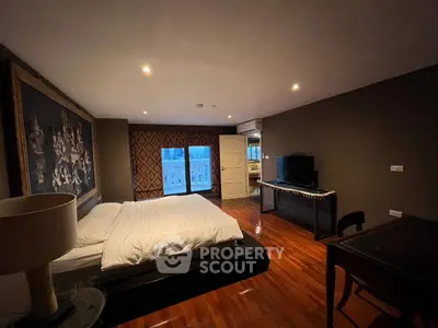 Spacious bedroom with elegant decor and large window offering natural light and scenic views.