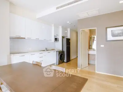 Modern kitchen with sleek white cabinets and integrated appliances in open layout.