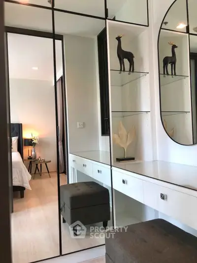 Stylish bedroom with mirrored wardrobe and elegant decor in modern apartment