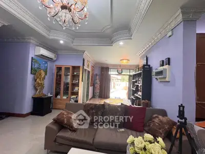 Luxurious living room with elegant chandelier and plush seating in a spacious open layout.