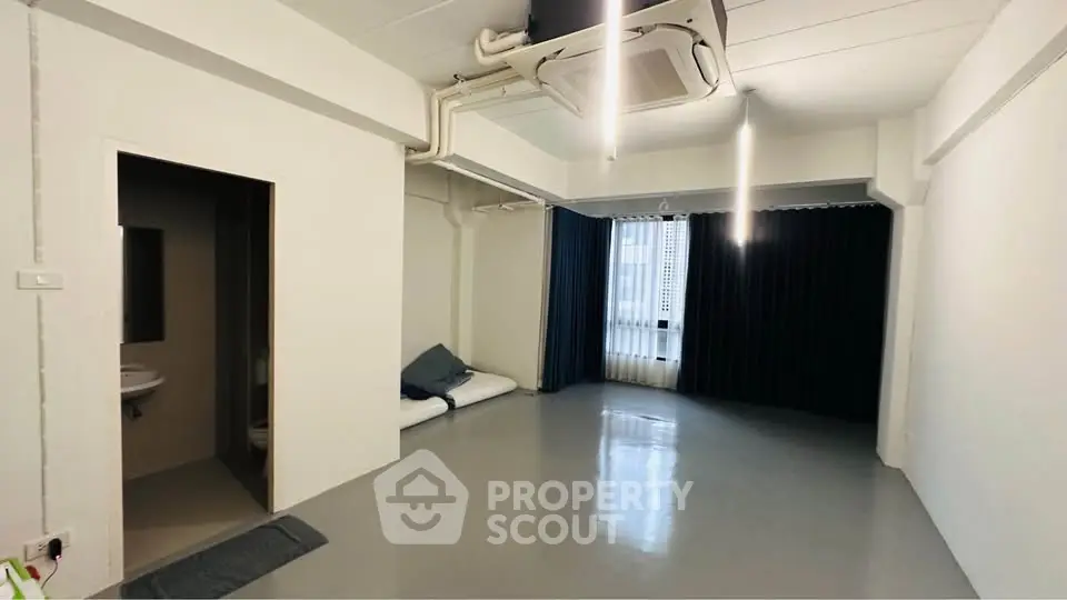 Spacious modern living room with sleek flooring and large windows for natural light.