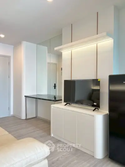 Modern living room with sleek TV stand and mirrored wall, featuring contemporary design and neutral tones.