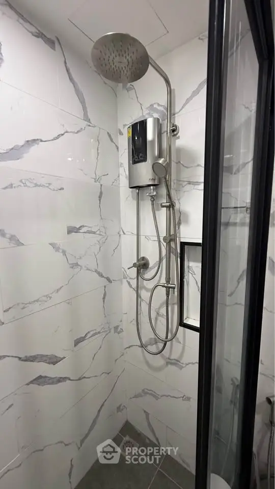 Modern bathroom with sleek shower fixtures and marble-patterned tiles