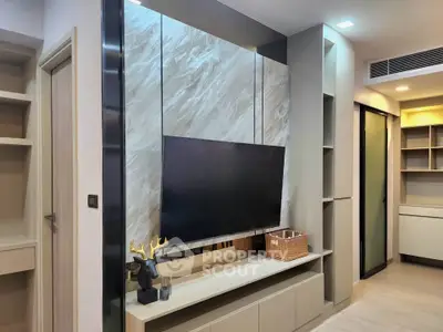 Modern living room with sleek TV setup and stylish shelving in a contemporary apartment.