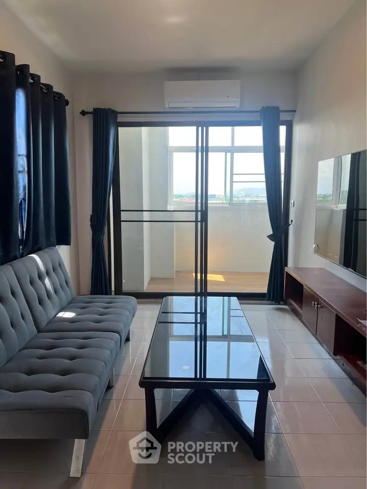 Modern living room with balcony view, featuring sleek furniture and abundant natural light.