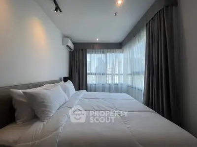 Spacious bedroom with large windows and modern decor, offering ample natural light and a cozy atmosphere.
