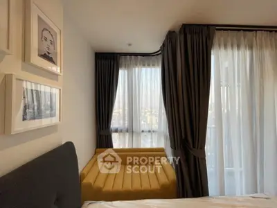 Cozy bedroom with stylish yellow sofa and large windows offering city views.