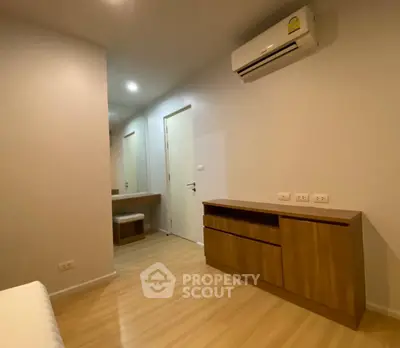 Modern bedroom with wooden flooring and built-in air conditioning unit.
