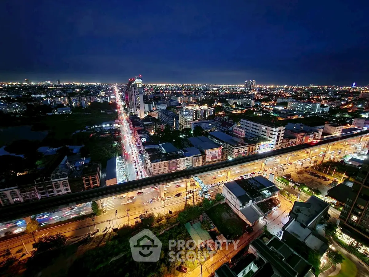 Stunning cityscape view from high-rise apartment at night, showcasing vibrant urban lights and bustling streets.