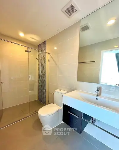 Modern bathroom with glass shower and sleek fixtures in a contemporary apartment.