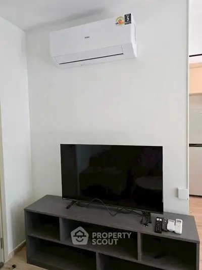 Modern living room with sleek TV setup and efficient air conditioning unit.