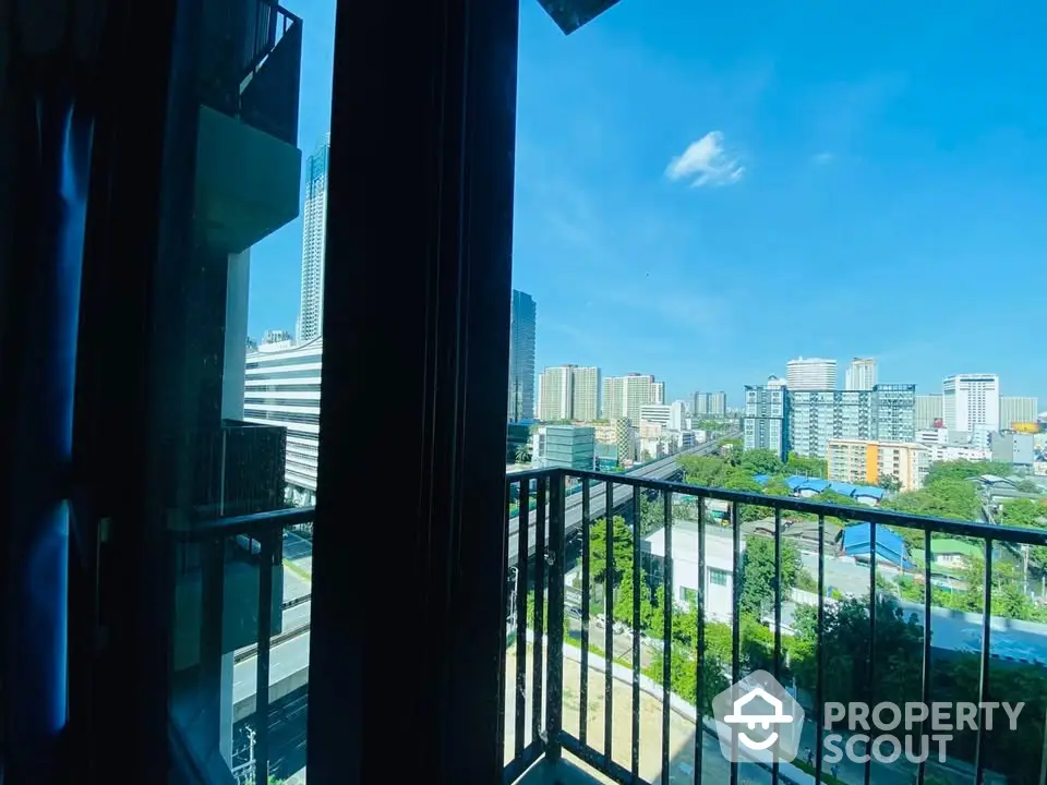 Stunning cityscape view from a modern balcony with clear blue skies and urban skyline.