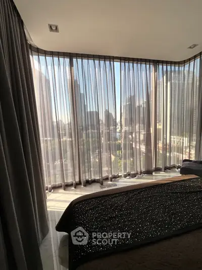 Luxurious bedroom with floor-to-ceiling windows offering stunning city views and elegant curtains.