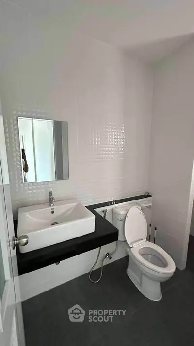 Modern bathroom with sleek sink and toilet in a minimalist design.