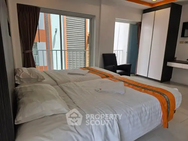 Modern bedroom with twin beds and balcony view in urban apartment