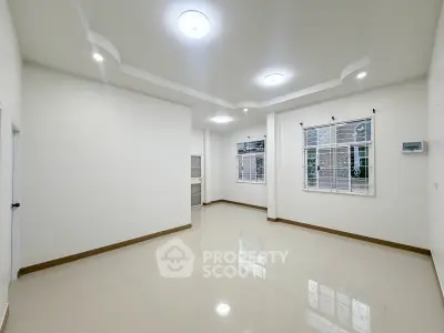Spacious and bright living room with modern ceiling lights and large windows.