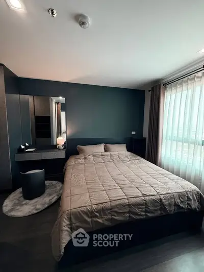 Modern bedroom with stylish decor and large window offering natural light