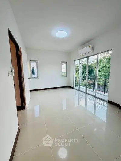 Spacious empty room with large windows and balcony access, perfect for customization.