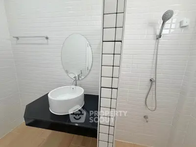 Modern minimalist bathroom with sleek fixtures and white subway tiles.