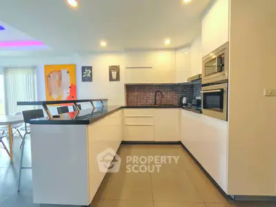 Modern kitchen with sleek white cabinets and built-in appliances in a stylish open layout.