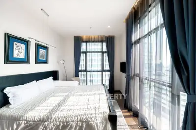 Bright and spacious bedroom with large windows and modern decor in a luxury apartment.
