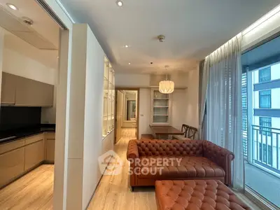 Modern living room with elegant leather sofa and open kitchen layout