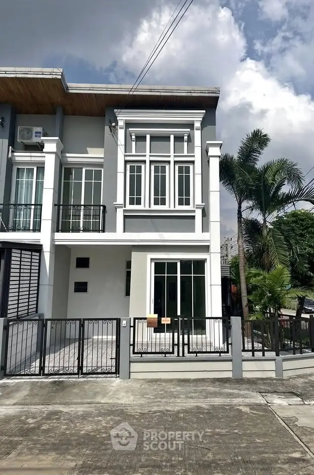 Modern townhouse with sleek design and spacious driveway in a suburban neighborhood.