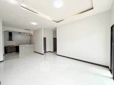 Spacious modern living room with open kitchen and elegant lighting