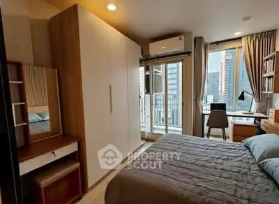 Modern bedroom with balcony and city view, featuring stylish furniture and ample natural light.