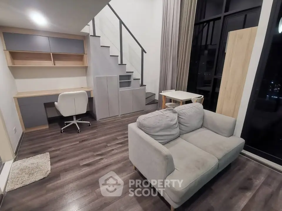 Modern duplex living room with sleek staircase and cozy seating area
