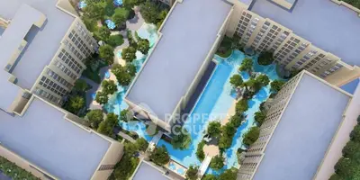 Aerial view of modern residential complex with lush gardens and swimming pools.