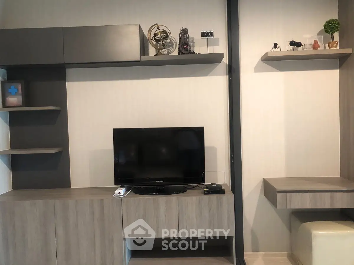 Modern living room with sleek wooden cabinetry and mounted TV