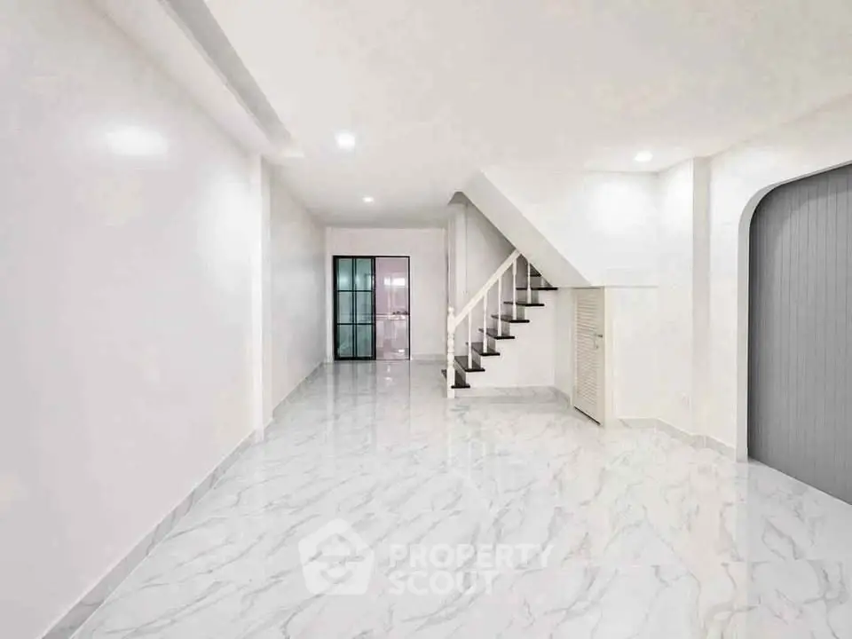 Spacious modern interior with marble flooring and elegant staircase, perfect for stylish living.