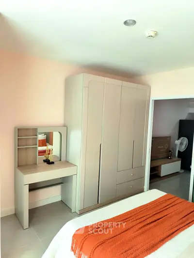Modern bedroom with sleek wardrobe and cozy decor in a stylish apartment.