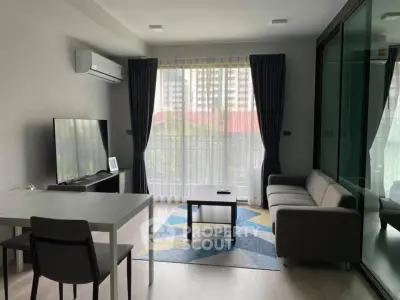 Modern living room with large window, stylish furniture, and air conditioning in a high-rise apartment.