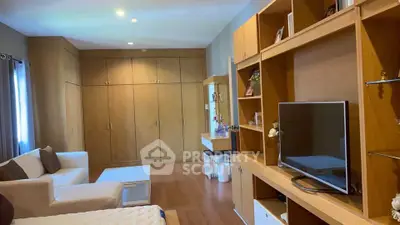 Spacious living room with modern wooden cabinetry and cozy seating area.