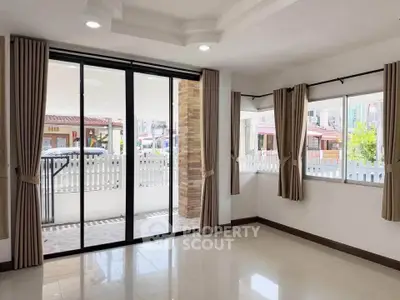 Spacious living room with large windows and sliding glass doors opening to a patio, perfect for natural light.