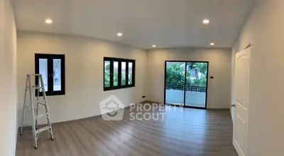 Spacious unfurnished room with large windows and balcony access, ideal for customization.
