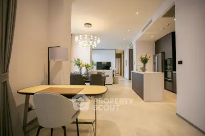 Modern open-plan living and dining area with elegant decor and contemporary lighting.