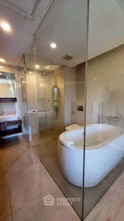 Luxurious modern bathroom with glass shower and elegant bathtub in a contemporary home.