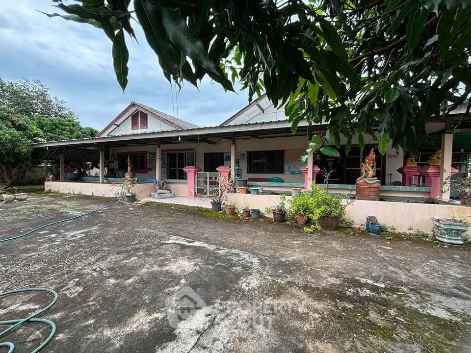 Charming rustic house with spacious outdoor area and lush greenery, perfect for serene living.