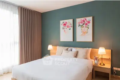 Elegant bedroom with stylish decor, featuring a cozy bed, bedside lamps, and floral artwork on a teal accent wall.
