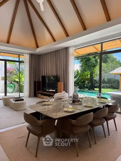 Luxurious open-plan living room with pool view and elegant dining area, perfect for entertaining.