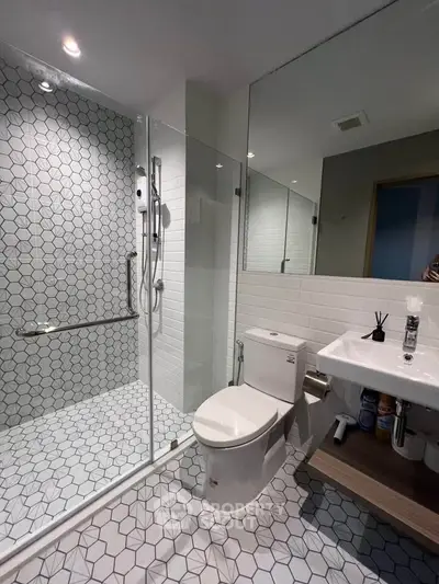 Modern bathroom with glass shower and stylish hexagonal tiles