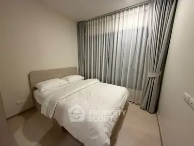 Cozy bedroom with elegant curtains and a comfortable bed in a modern apartment.