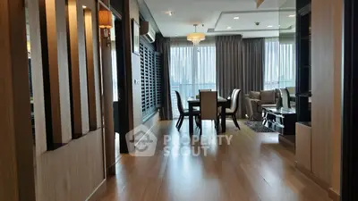 Luxurious open-plan living and dining area with elegant decor and large windows offering natural light.